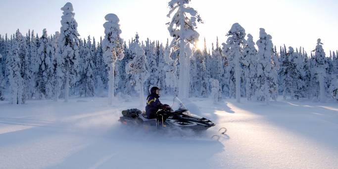 Snowmobiling by the forest | Finland