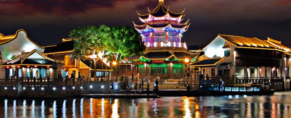 View of Suzhou lit up at night from across the water