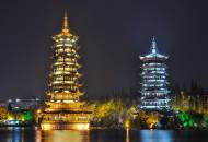 The Sun and Moon twin pagodas lit up at night in Guilin on the edge of Shan Lake