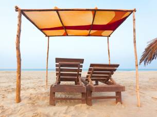 Sunloungers and awning on a beach in Goa