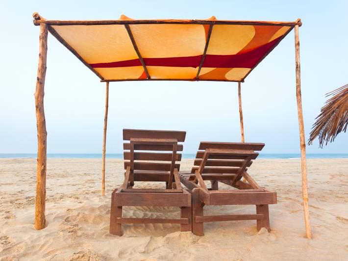 Sunloungers and awning on a beach in Goa