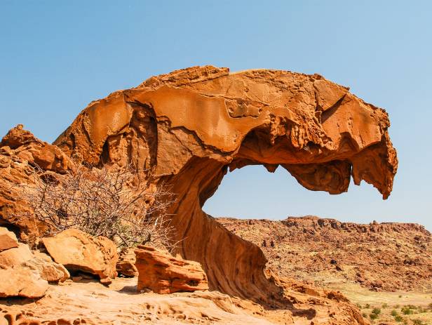 Curved rock against a bright blue sky at Twyfelfontein