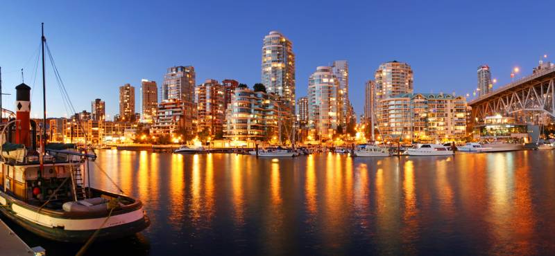 The attractive skyline of Vancouver at dusk with the city lights reflecting in the water