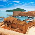 Aerial view of Dubrovnik, surrounded by water and filled with terracotta-roofed buildings