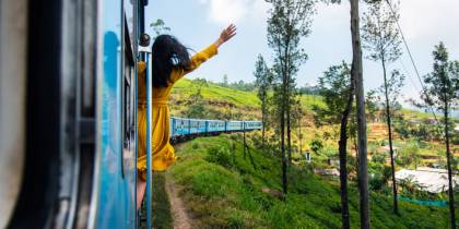 Woman enjoying train ride through Sri Lanka tea plantations