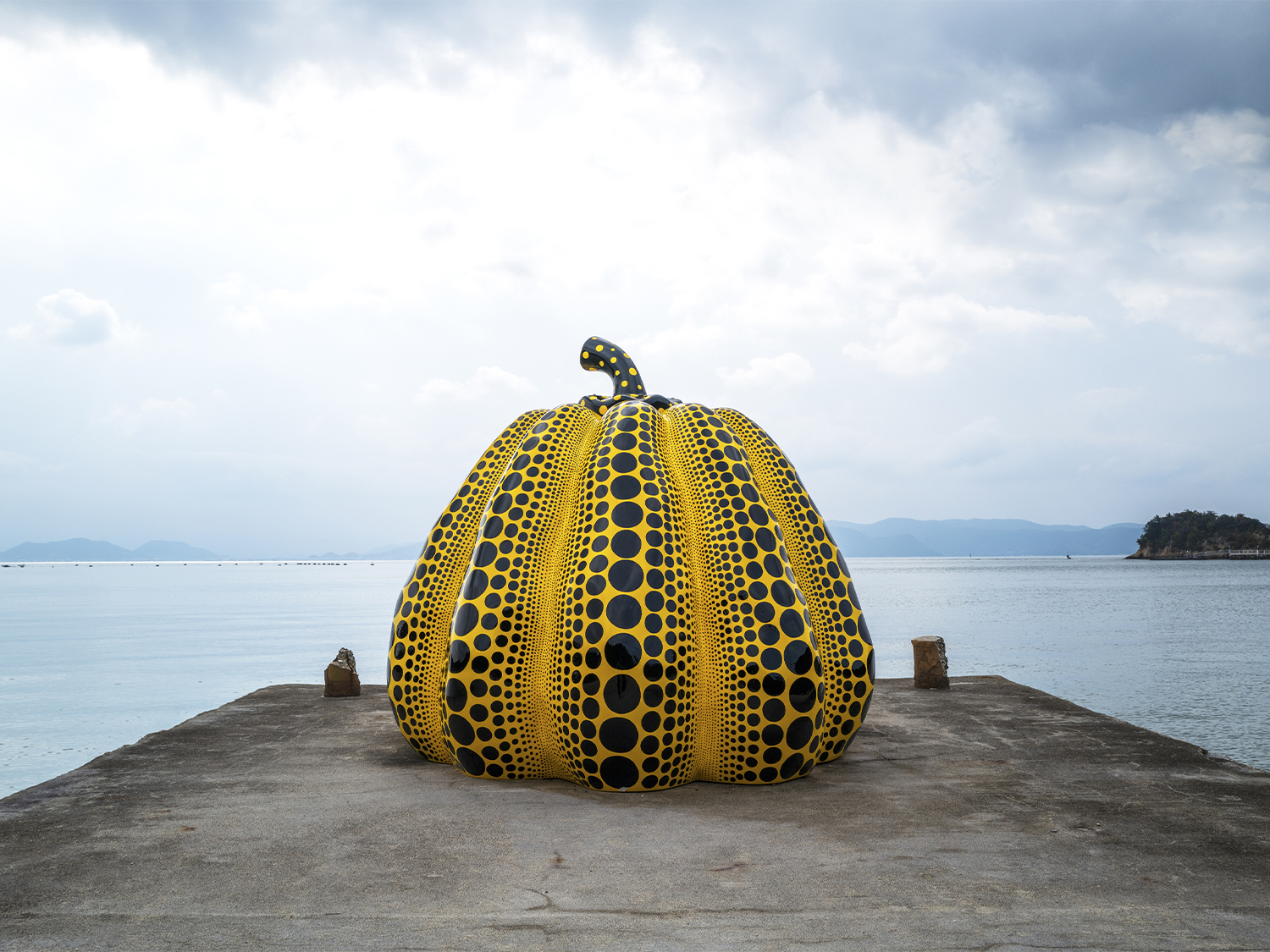 an art piece by Yayoi Kusama of a pumpkin covered in polka dots